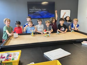 Kids celebrating a birthday around the robotics table