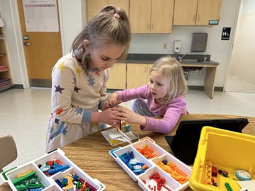 Two campers building a LEGO robot together