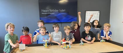 Kids celebrating a STEM birthday party with robots at UP Robotics