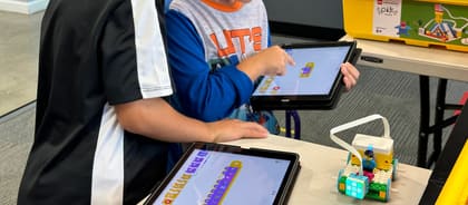 A student building and coding a LEGO robot in an UP Robotics after-school class