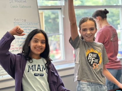 Two students celebrating their robot build during class