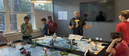 An UP Robotics coach leading a class discussion with students