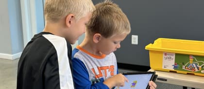 Two students working together on a tablet during an UP Robotics class