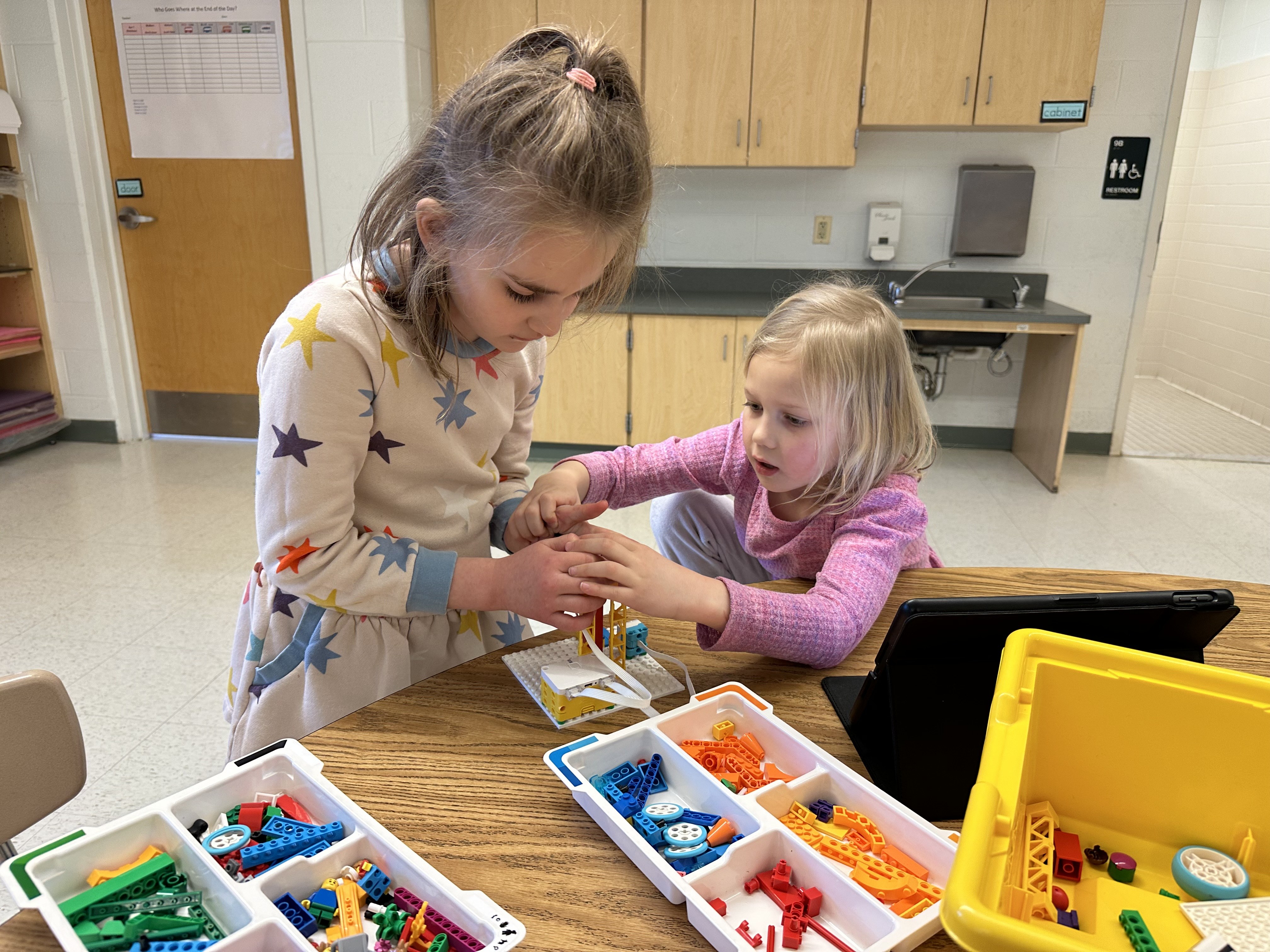 Two campers building a LEGO robot together